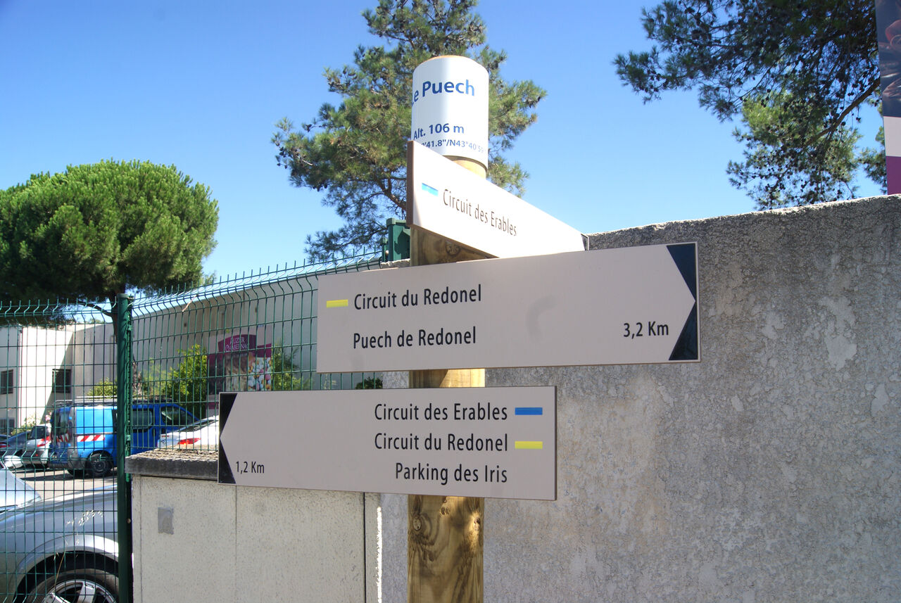Panneau de balisage indiquant la direction de différentes balades urbaines